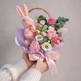 Composição de Páscoa com coelhinho e flores em uma cesta